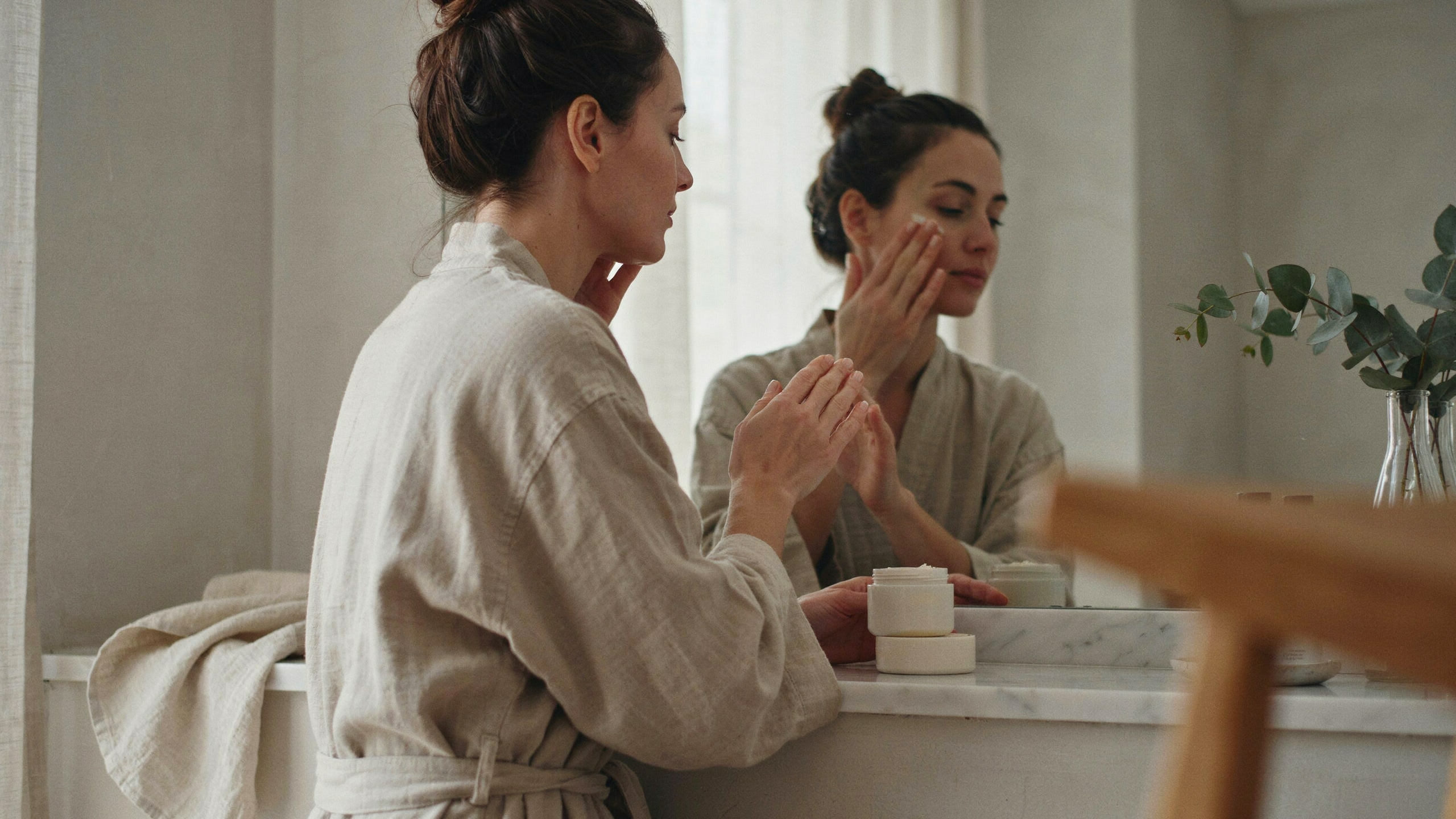 Application douce d'un hydratant sur une peau sensible dans une routine minimaliste